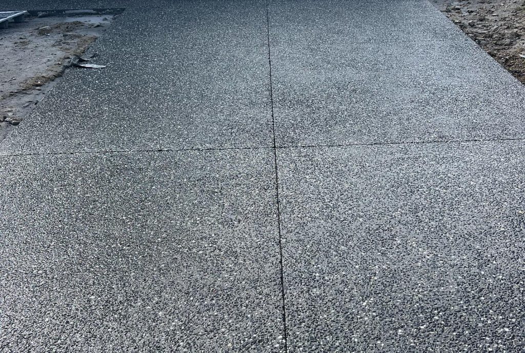 Exposed aggregate concrete driveway done in Blizzard Ice 19 half black.